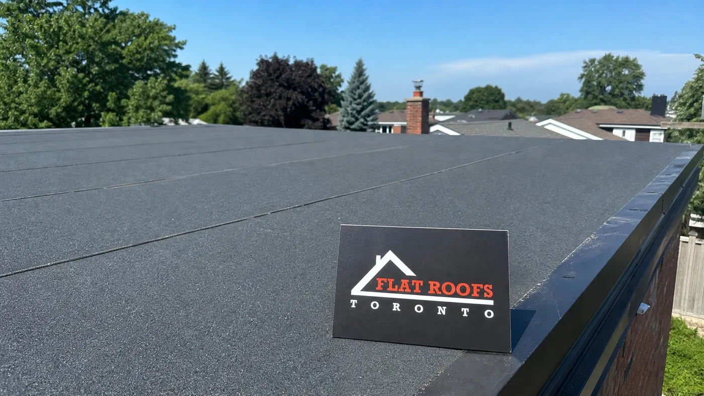 Wide view of a completed torch-on roof membrane on a Toronto low-slope roof under summer daylight