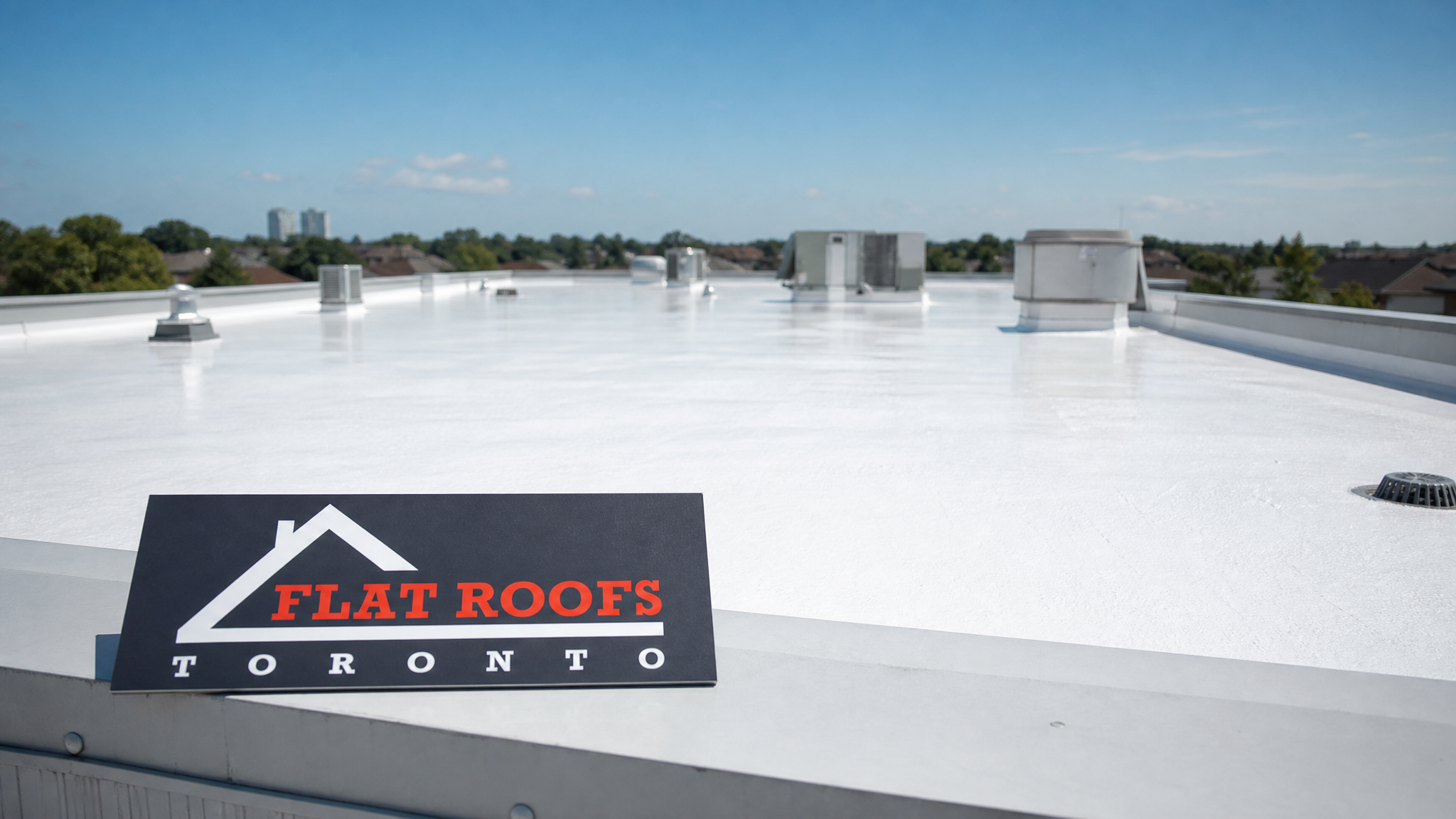 Toronto green standard reflective roof coating applied to a commercial flat roof in summer daylight