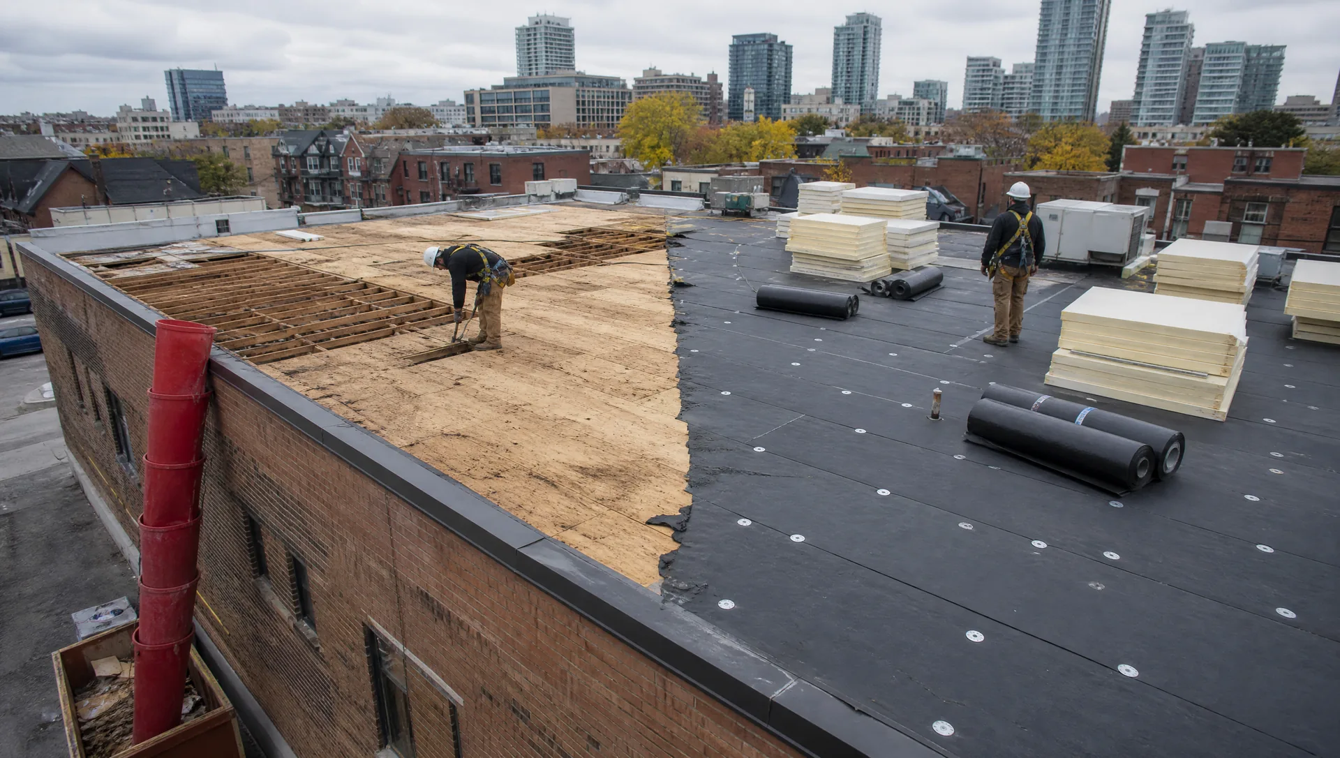 Flat roof replacement in progress with tear-off and new insulation boards