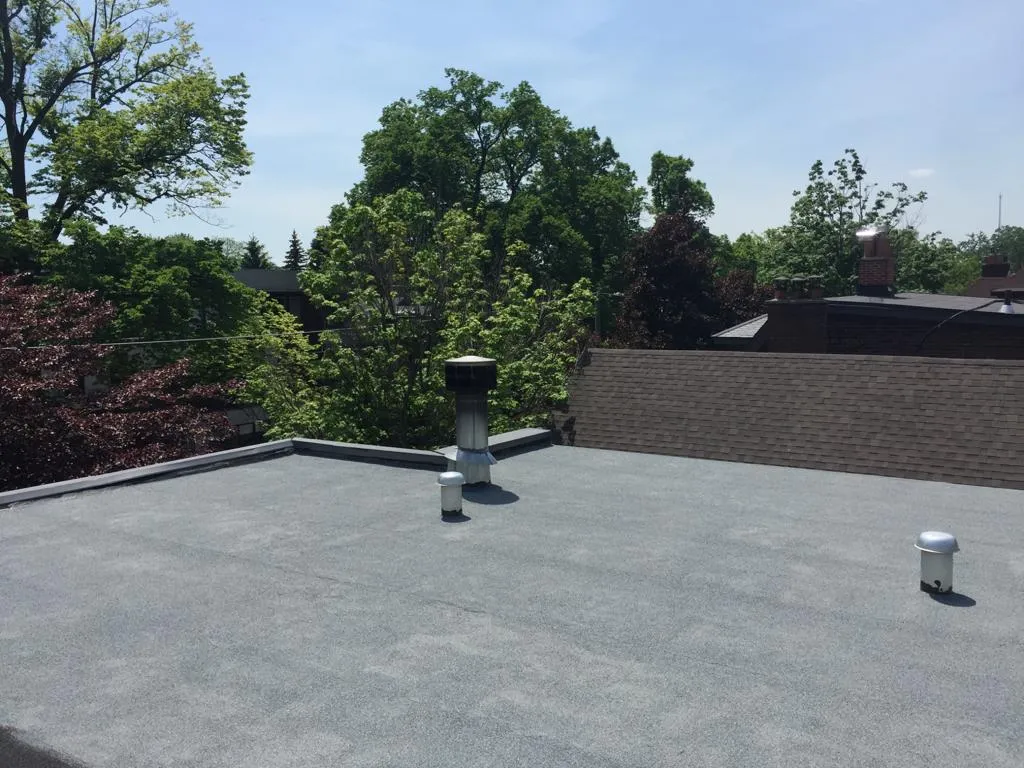 Completed residential flat roof finished with a ceramic granule cold-ply surface
